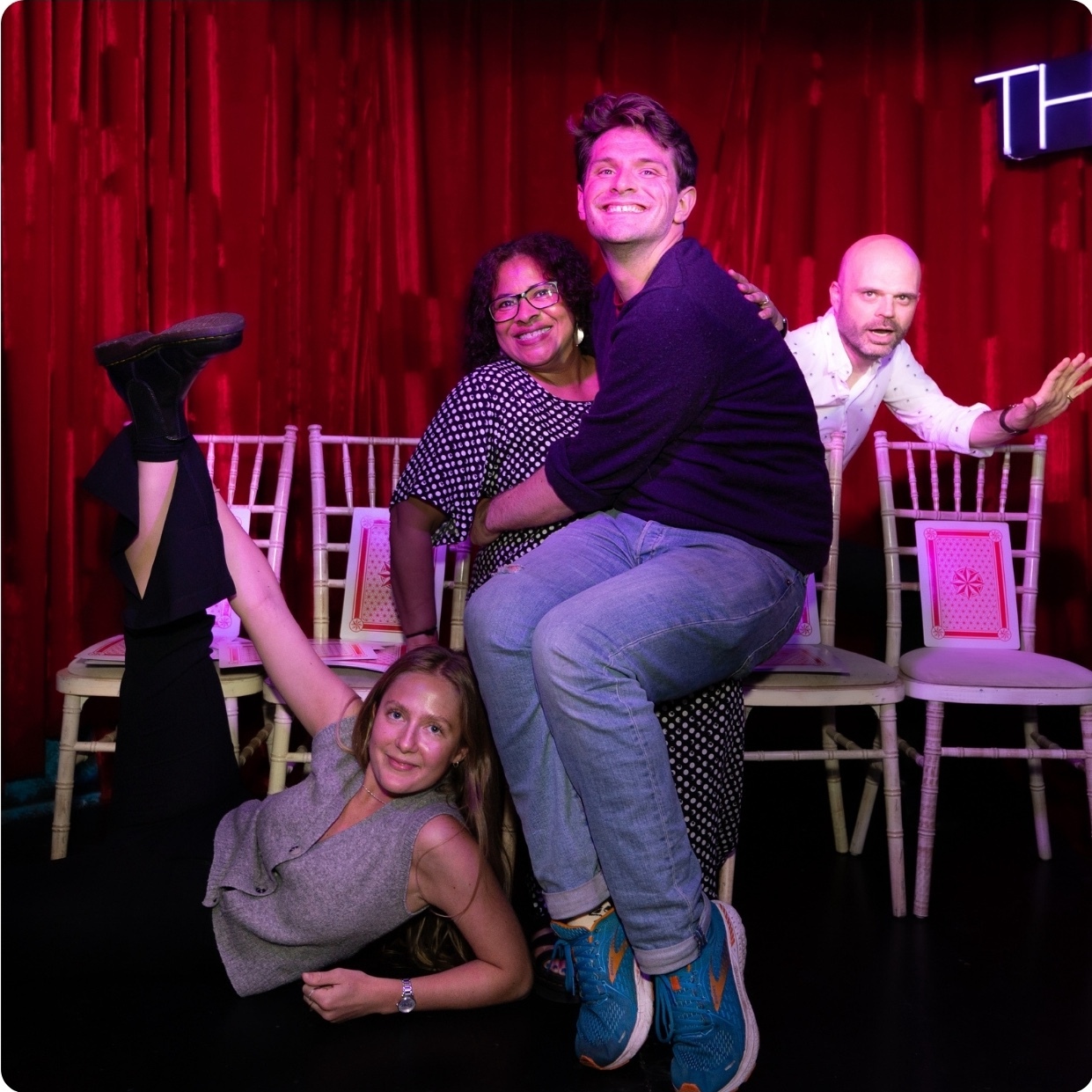 three quizmasters posing on stage